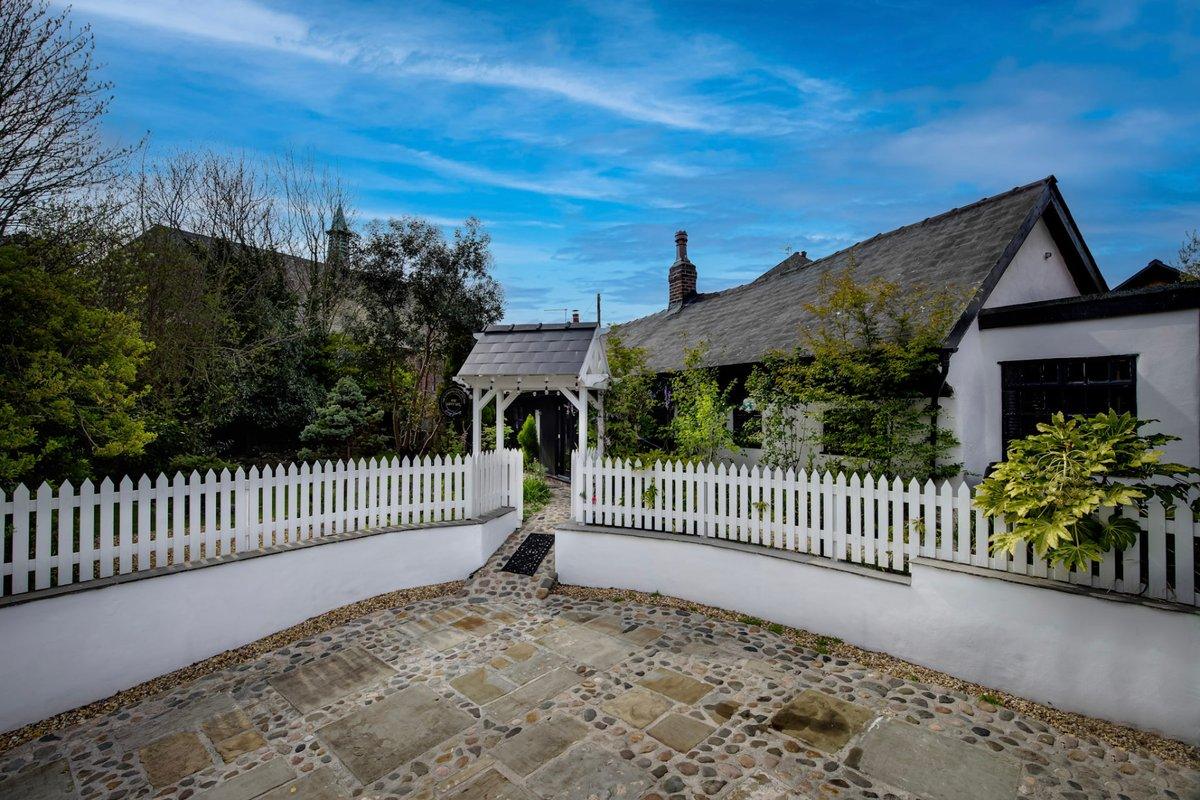 Front of the cottage with white picket fence and cobbled driveway